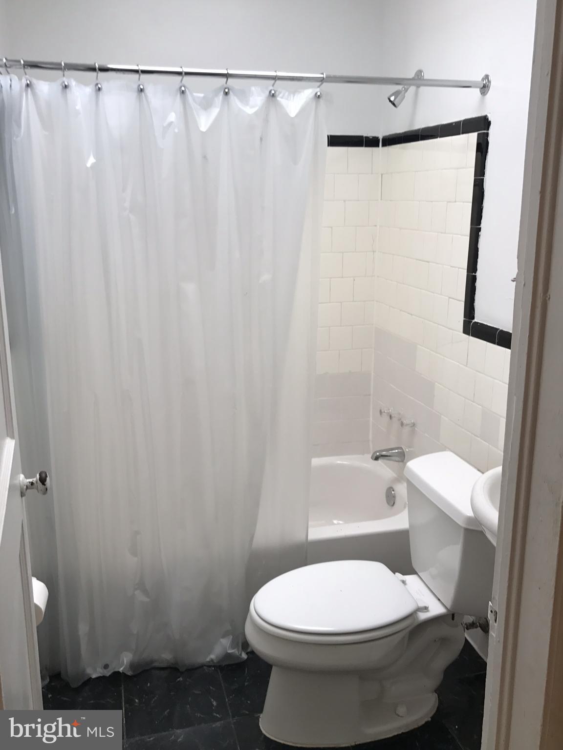 627 Cheraton Road Baltimore, MD 21225 - Photo 14 of 22 a white toilet sitting next to a shower curtain