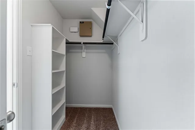 an empty room with a chandelier fan and windows
