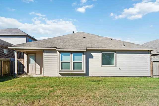 a view of a yard in front of a house with plants and large tree