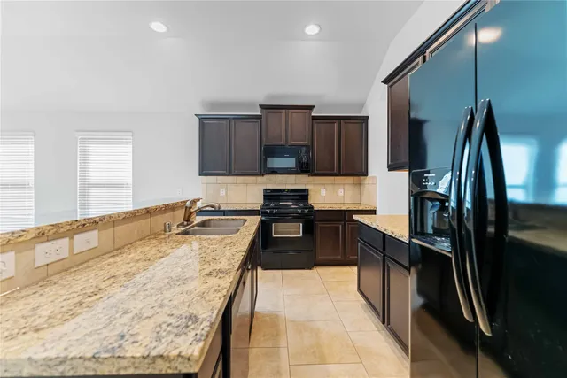 a kitchen with stainless steel appliances granite countertop a stove and a microwave