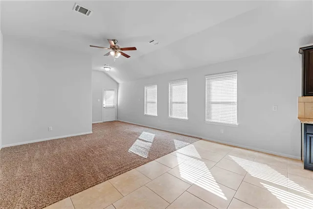 a view of a room with a ceiling fan and window