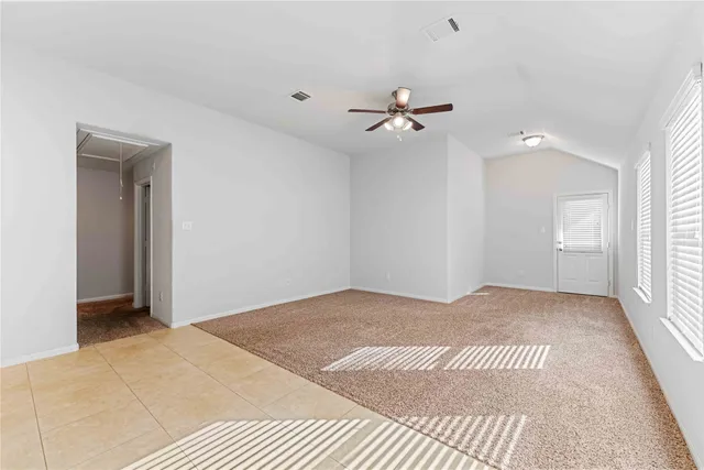 an empty room with a ceiling fan and a window