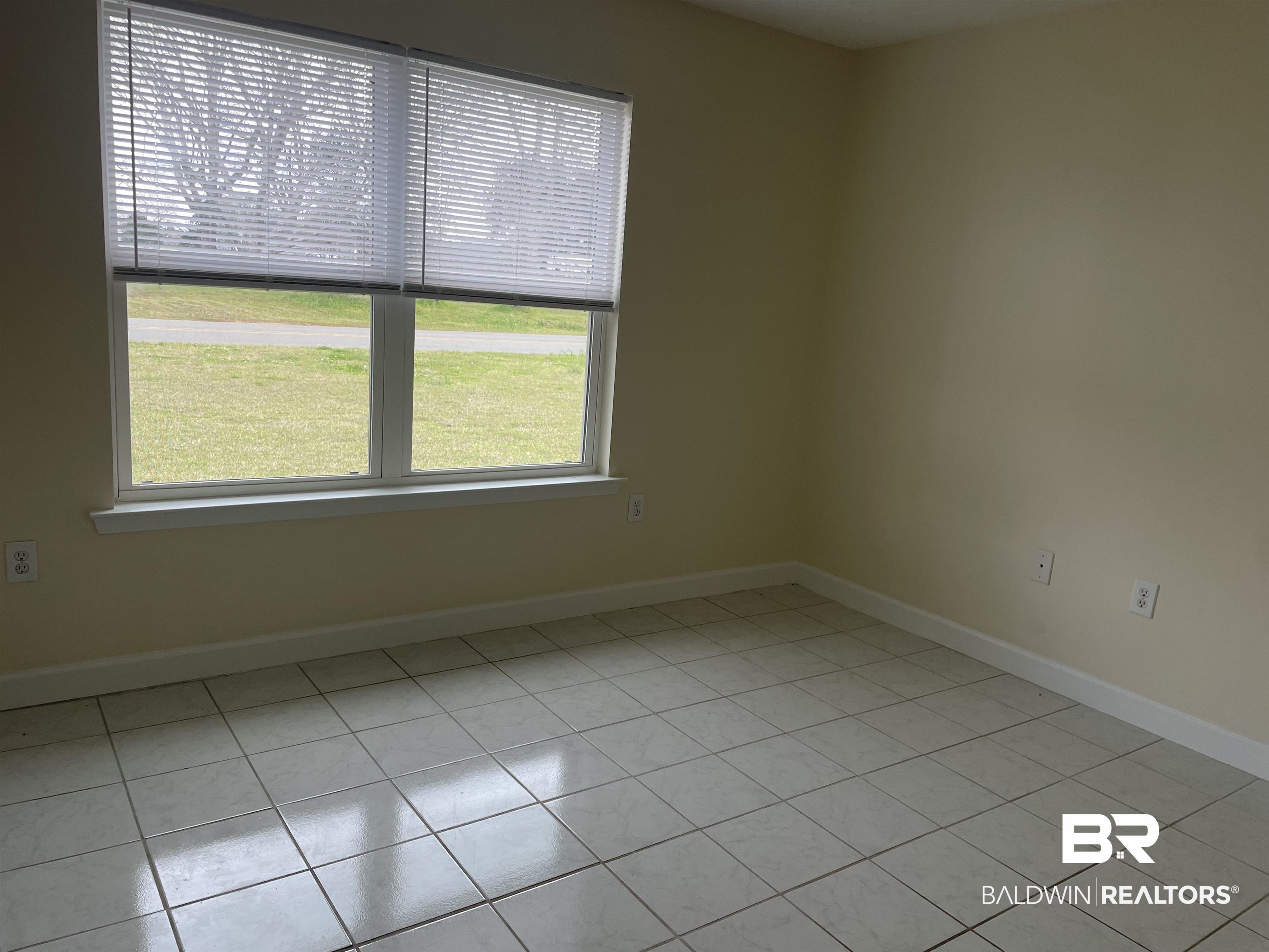 23575 Fountain Street Robertsdale, AL 36567 - Photo 3 of 19 Front bedroom featuring light tile patterned floors and baseboards