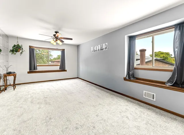 en empty room with windows and ceiling fan