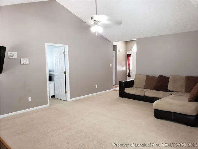 a living room with furniture and a ceiling fan