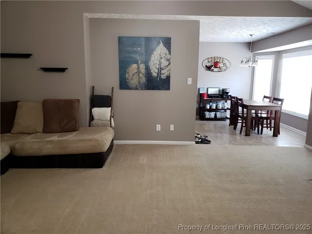 a living room with furniture and a dining table with window