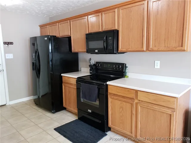 a kitchen with stainless steel appliances granite countertop a refrigerator stove and microwave