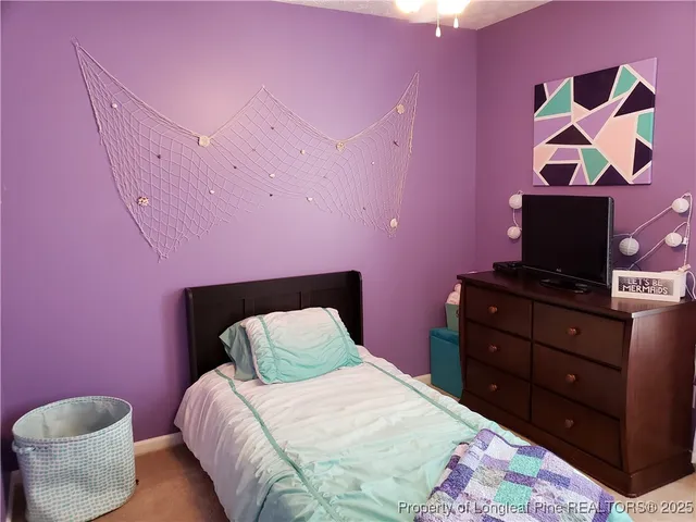 a bedroom with a bed and a painting on the wall