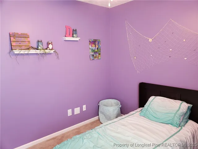 a bedroom with pink walls and pink rug