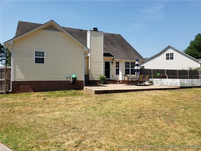 a view of pool with lawn chairs under an umbrella