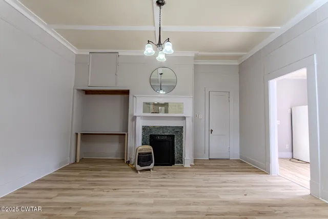 a view of a room with wooden floor and a refrigerator