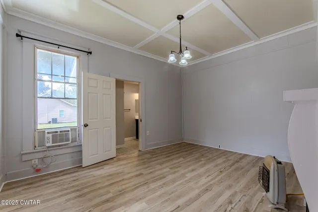 a view of a livingroom with wooden floor and a fireplace