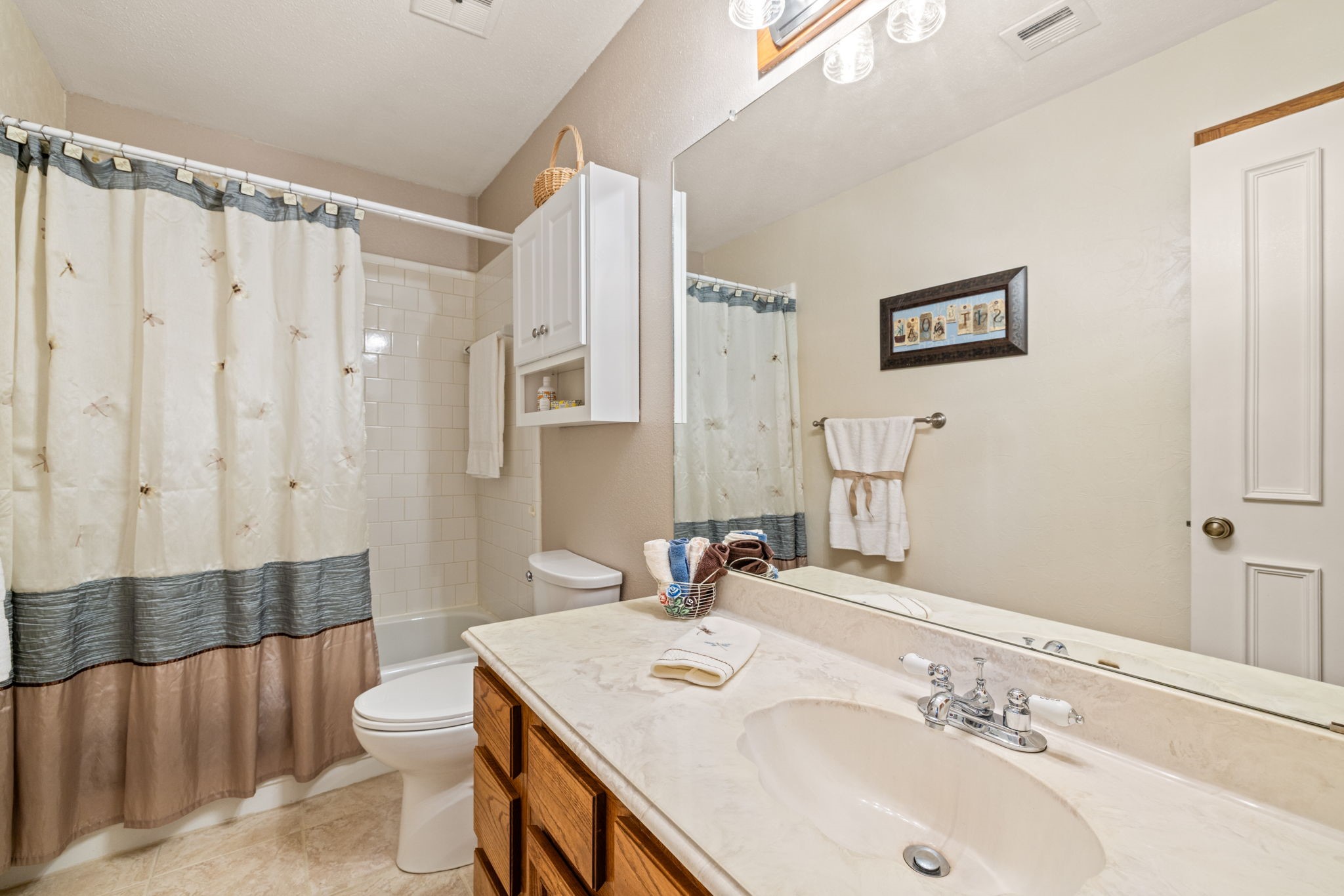 9102 Woodhouse Drive Spring, TX 77379 - Photo 20 of 32 UPSTAIRS HALL BATHROOM - The toilet in this bathroom has also been replaced with the comfort height toilet. Plenty of storage space, with linen cabinet behind the door.