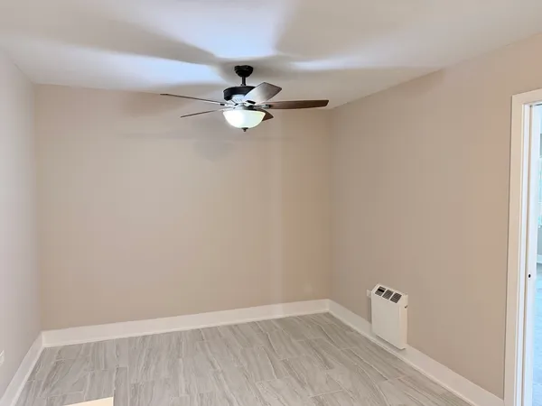 an empty room with a window and a ceiling fan