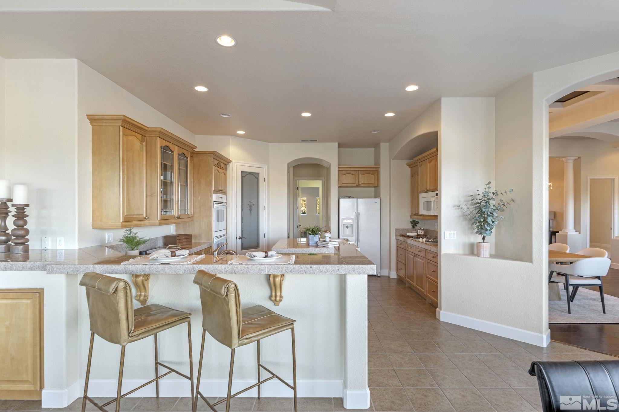 14760 Chateau Avenue Reno, NV 89511 - Photo 11 of 38 a dining hall with stainless steel appliances a dining table and chairs