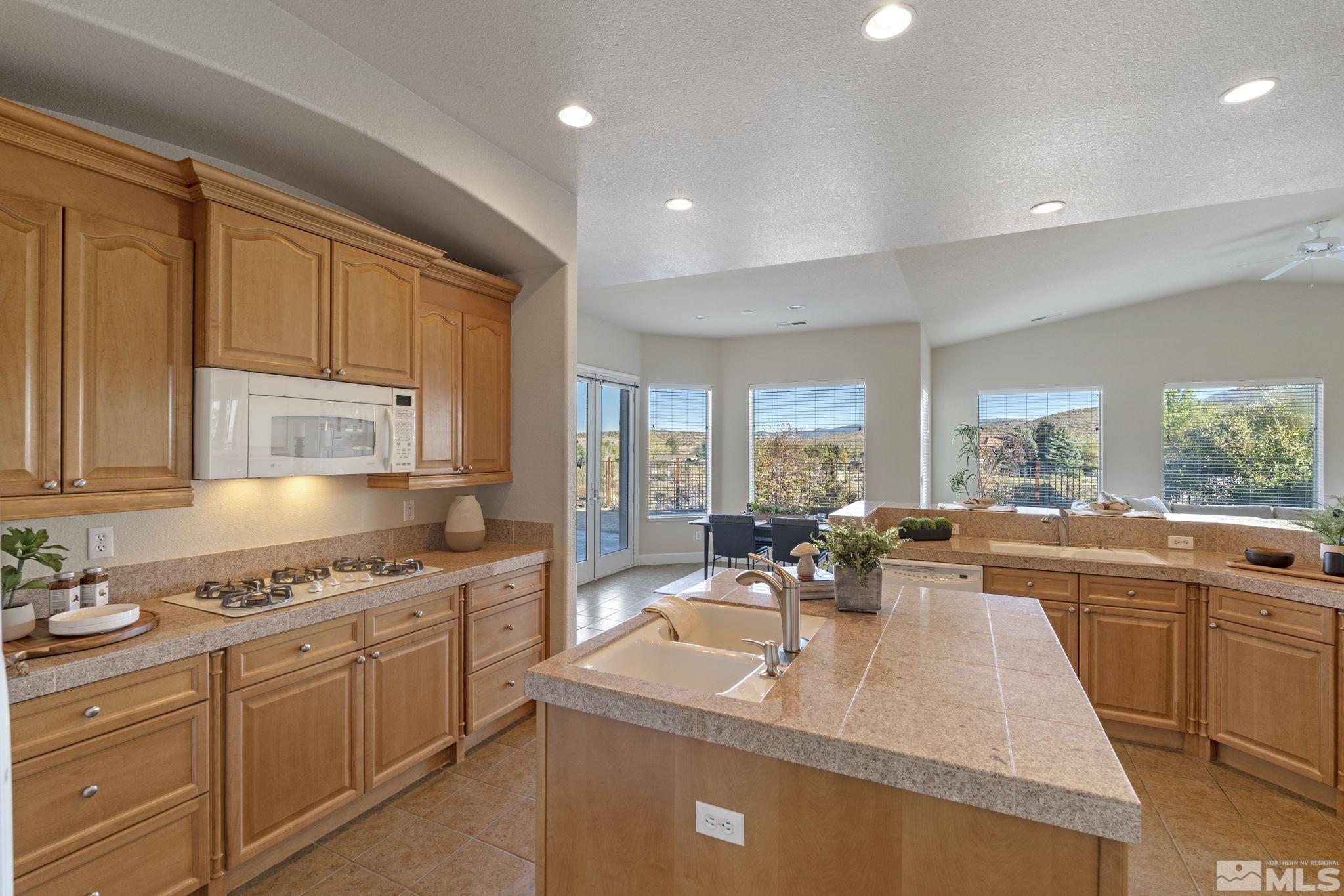 14760 Chateau Avenue Reno, NV 89511 - Photo 14 of 38 a view of a kitchen with kitchen island a sink stainless steel appliances cabinets and a counter top space