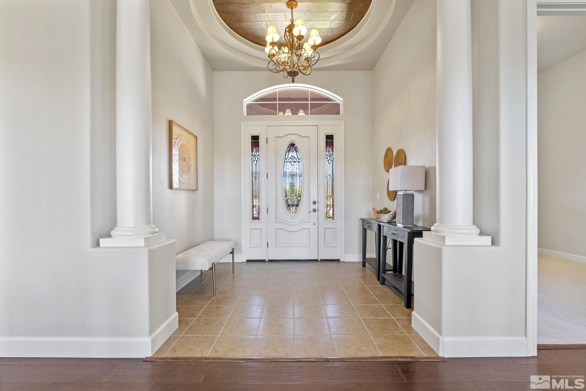 14760 Chateau Avenue Reno, NV 89511 - Photo 2 of 38 a view of a hallway with wooden floor and a chandelier