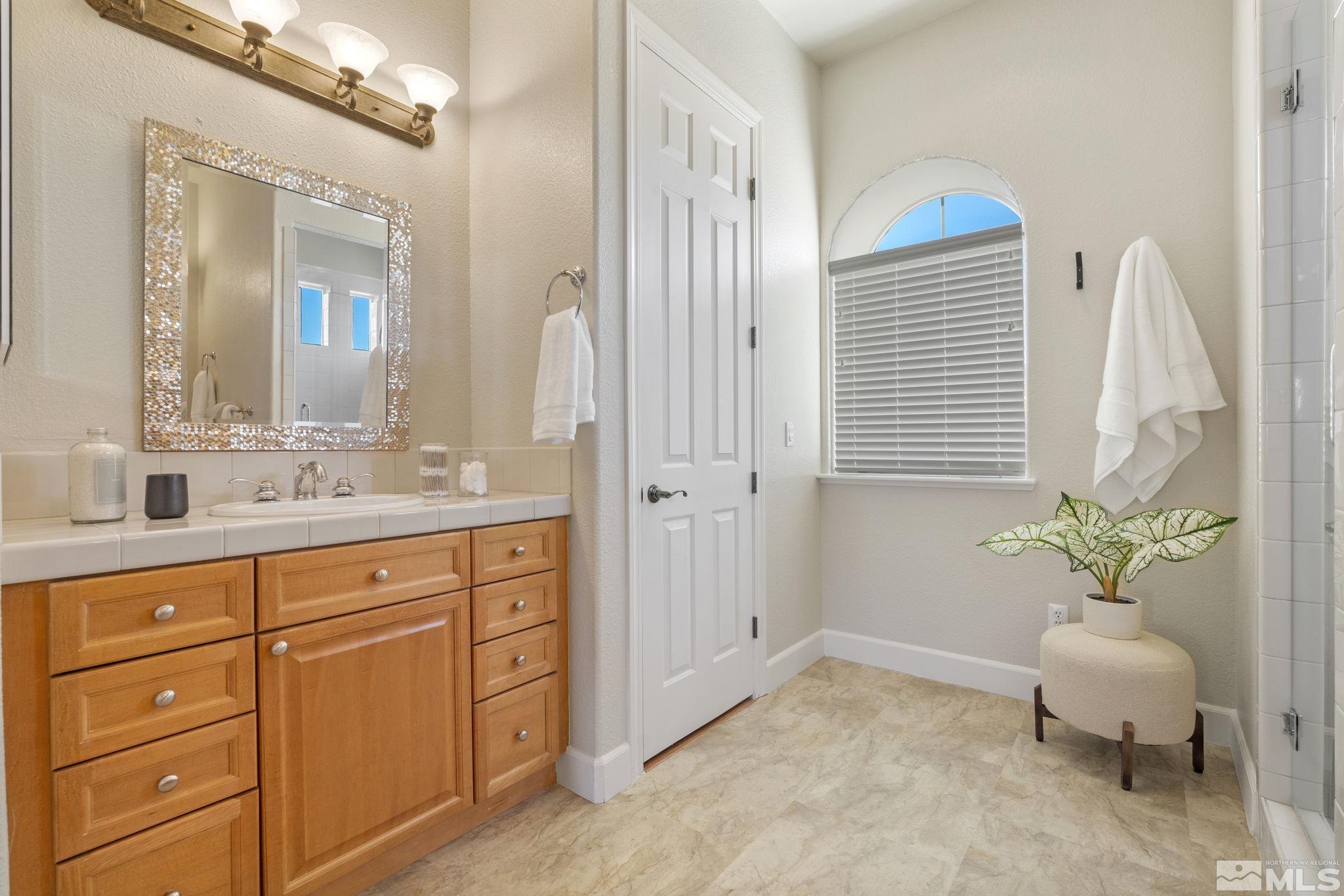 14760 Chateau Avenue Reno, NV 89511 - Photo 33 of 38 a spacious bathroom with a granite countertop sink and a mirror