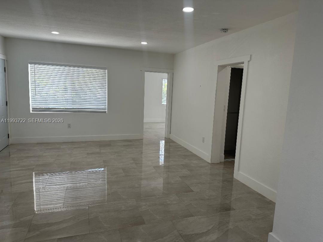 7115 Rue Granville, Unit D Miami Beach, FL 33141 - Photo 2 of 13 an empty room with windows and pillars in it