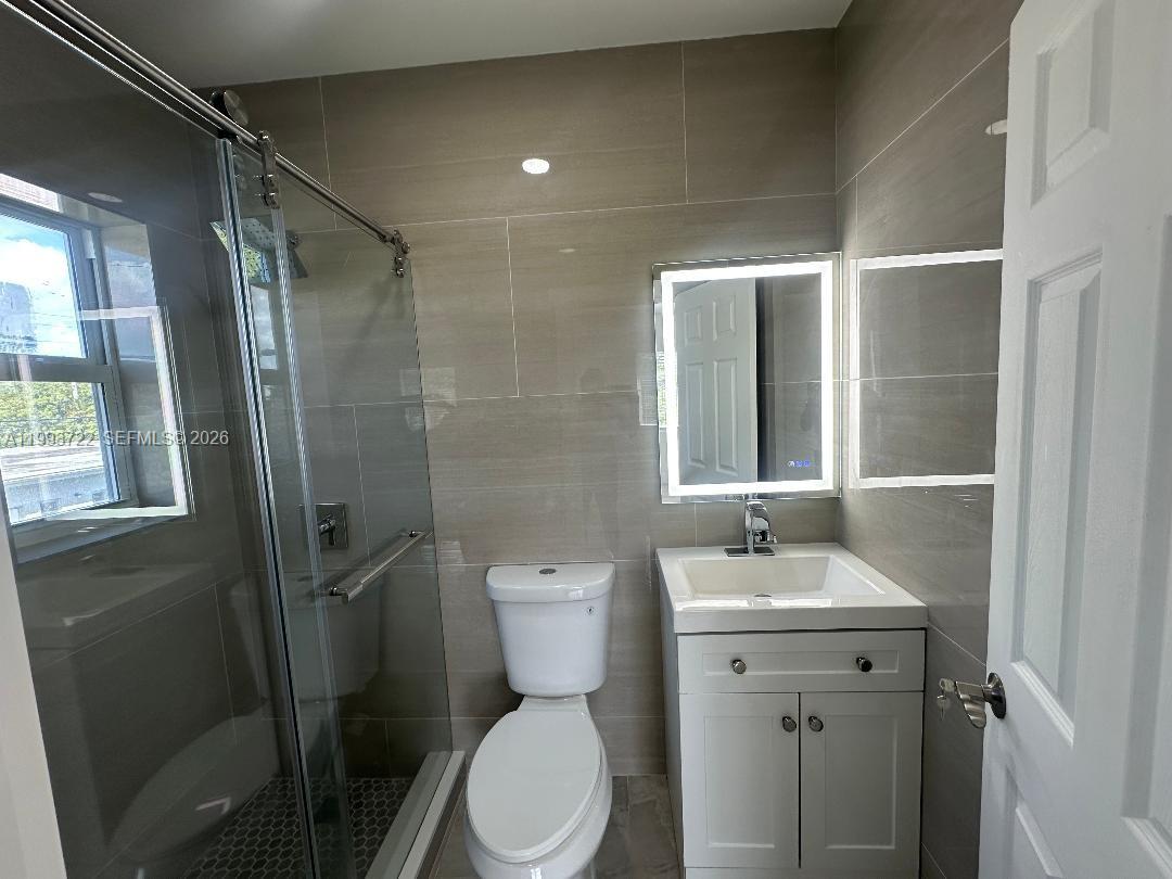 7115 Rue Granville, Unit D Miami Beach, FL 33141 - Photo 7 of 13 a bathroom with a toilet sink and shower
