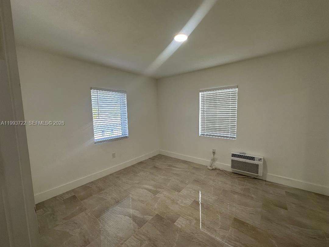 7115 Rue Granville, Unit D Miami Beach, FL 33141 - Photo 9 of 13 an empty room with windows