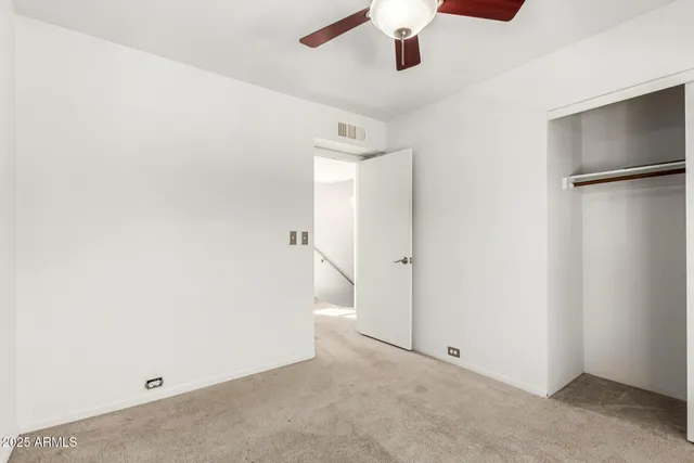 an empty room with a ceiling fan and a window