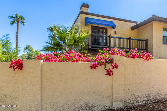 a front view of a house with a lot of flowers