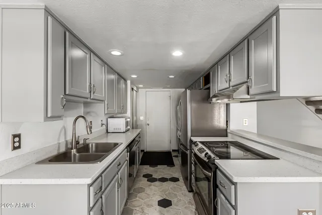 a kitchen with stainless steel appliances a sink stove and cabinets