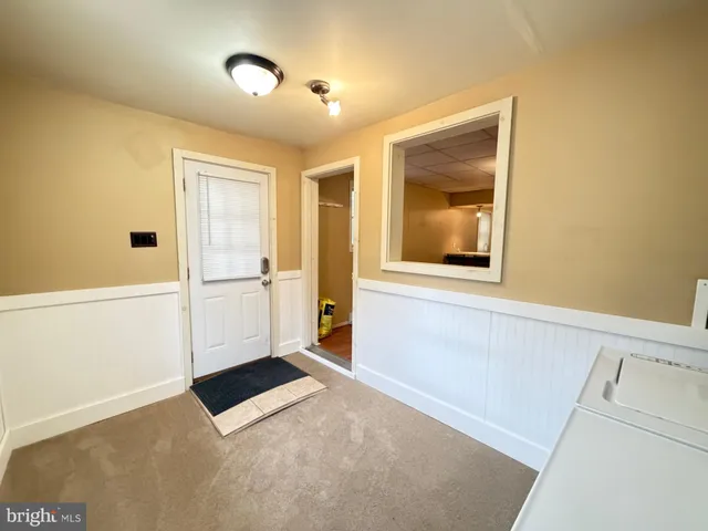 a view of a hallway with a white cabinet and a refrigerator