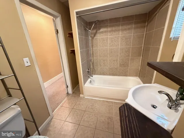 a bathroom with a tub a sink and a shower