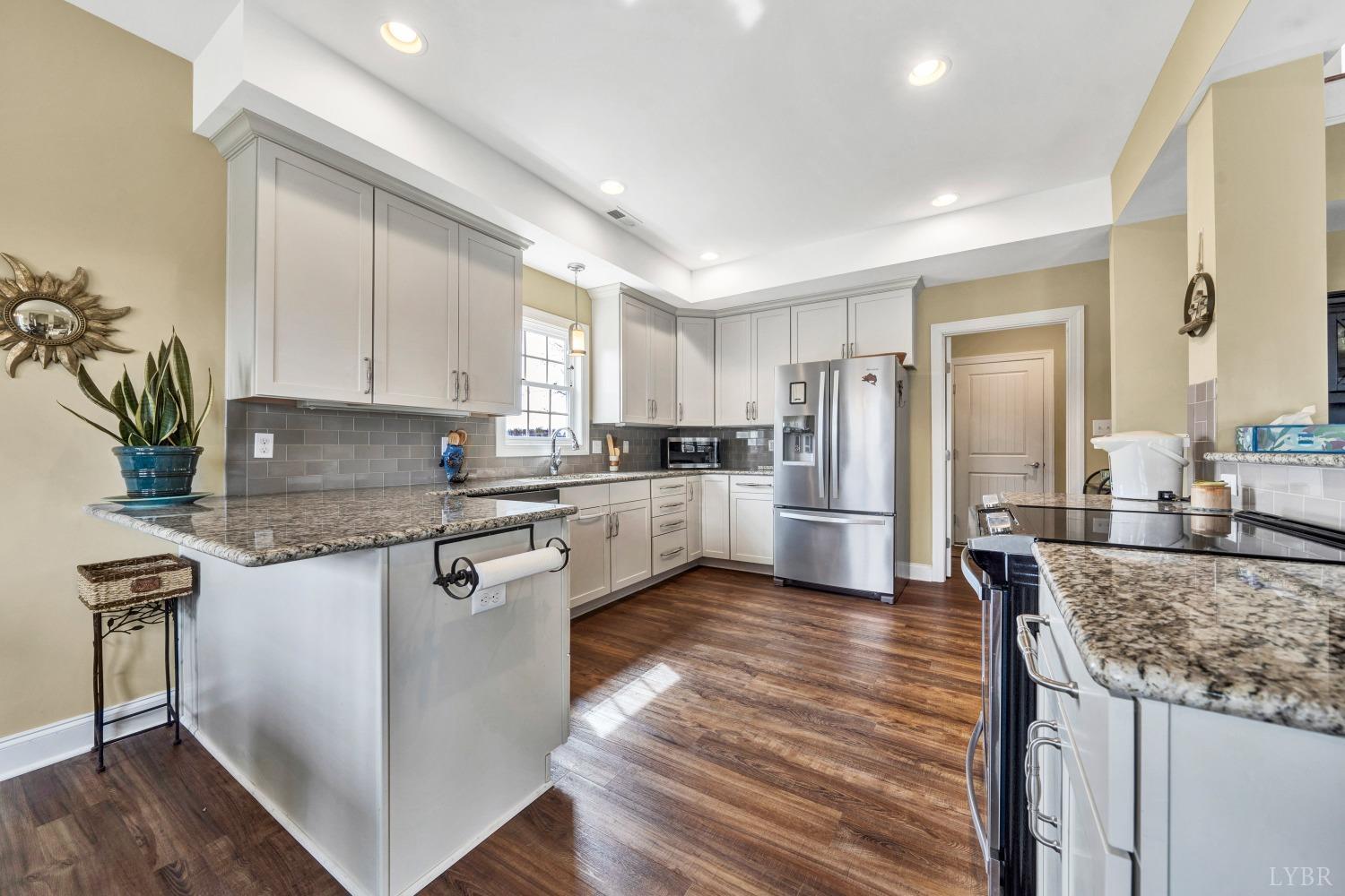 1333 Lynbrook Road Rustburg, VA 24588 - Photo 24 of 53 a kitchen with granite countertop kitchen island wooden floors and stainless steel appliances