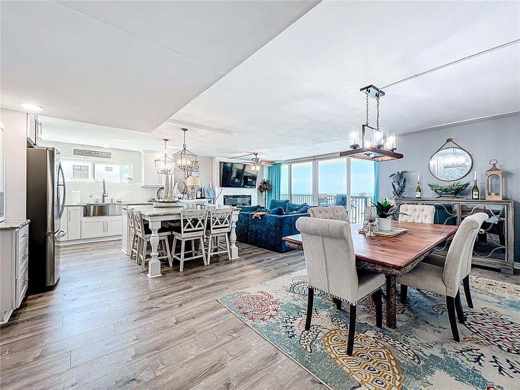 14146 Gulf Boulevard, Unit 3A Madeira Beach, FL 33708 - Photo 6 of 29 a dining room with wooden floor a chandelier a wooden table and chairs