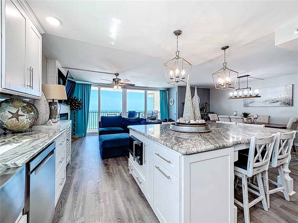 14146 Gulf Boulevard, Unit 3A Madeira Beach, FL 33708 - Photo 8 of 29 a kitchen with stainless steel appliances granite countertop a stove and a wooden floors
