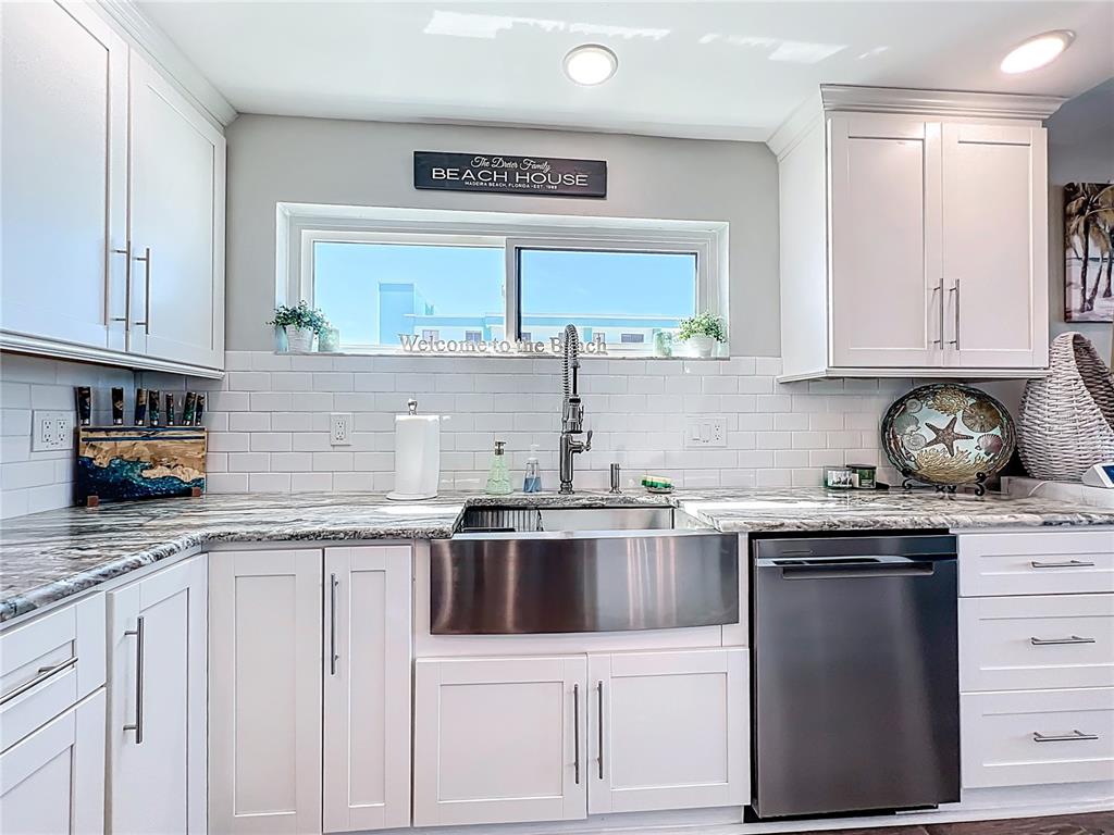 14146 Gulf Boulevard, Unit 3A Madeira Beach, FL 33708 - Photo 9 of 29 a kitchen with stainless steel appliances granite countertop a sink and cabinets