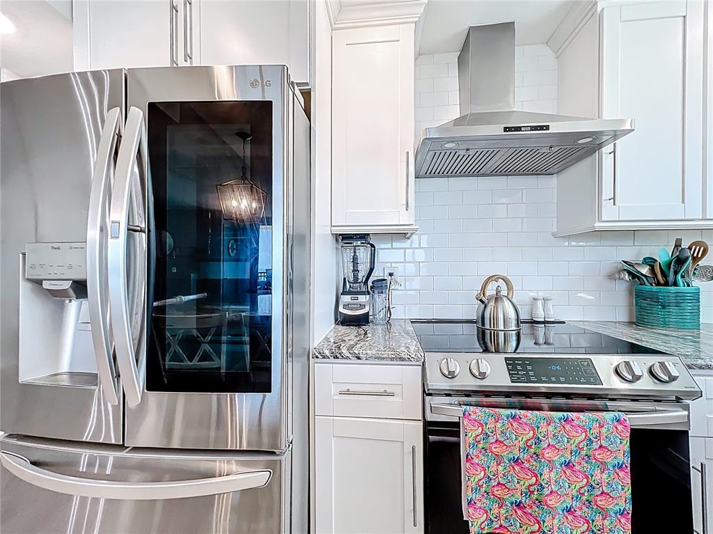 14146 Gulf Boulevard, Unit 3A Madeira Beach, FL 33708 - Photo 10 of 29 a kitchen with stainless steel appliances granite countertop a sink stove and refrigerator