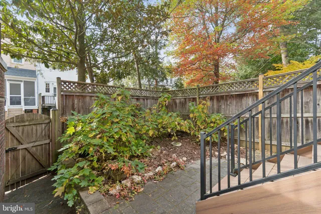 a backyard of a house with fountain table and chairs