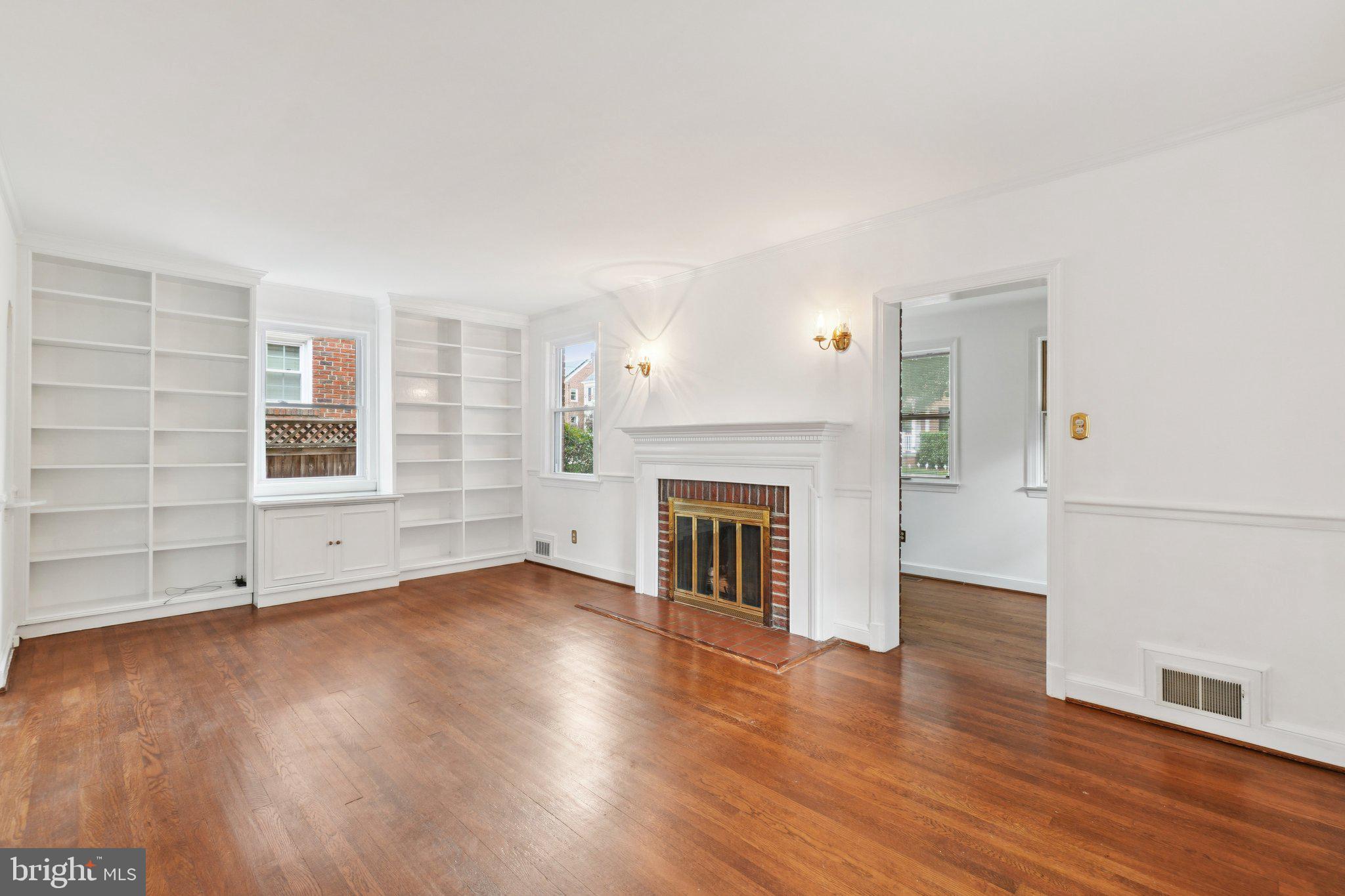 5008 44th Street Northwest Washington, DC 20016 - Photo 3 of 26 an empty room with wooden floor fireplace and windows
