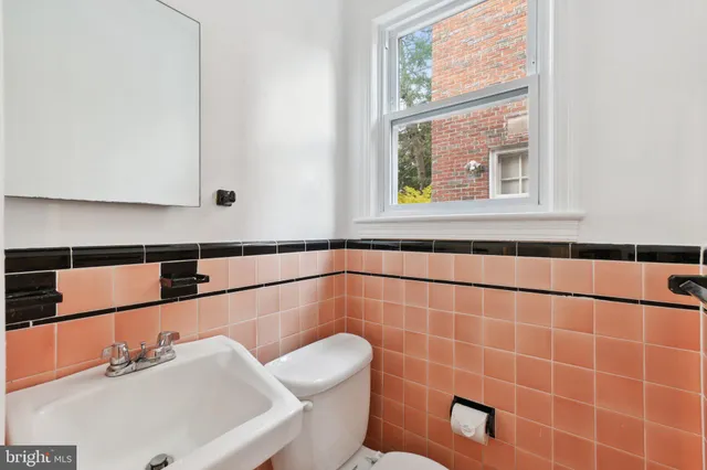 a bathroom with a sink mirror and toilet