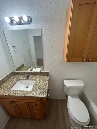 a bathroom with a toilet sink and mirror