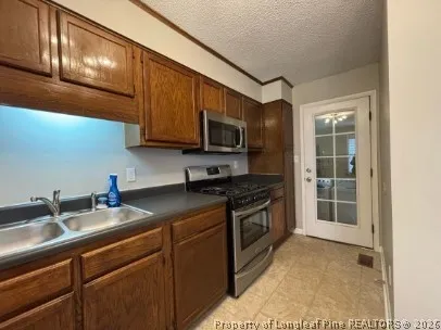 a kitchen with stainless steel appliances granite countertop a sink stove and microwave