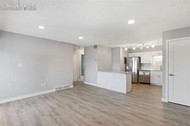 a view of a kitchen with a refrigerator and a sink