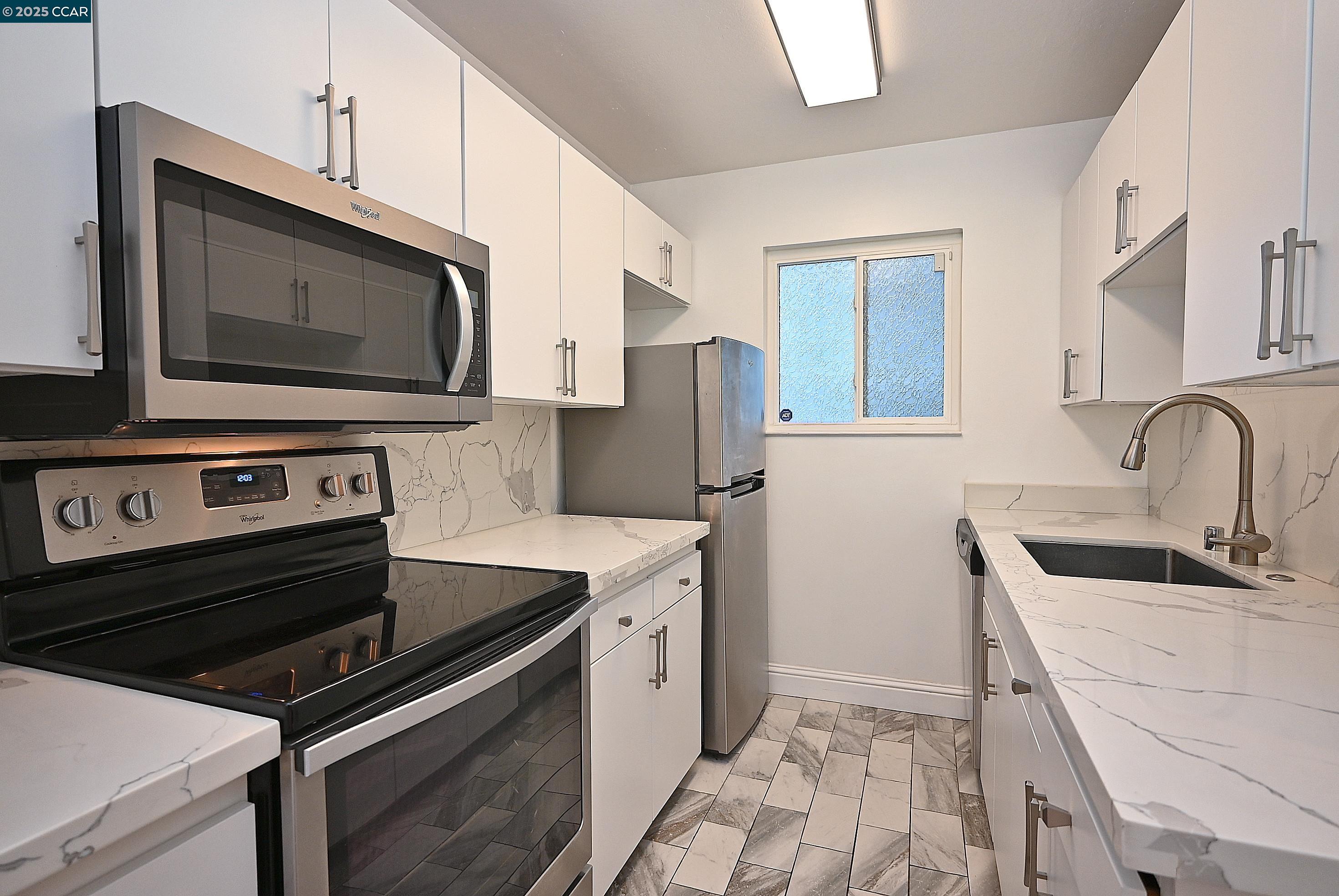 1425 Lakeside Drive, Unit 101 Oakland, CA 94612 - Photo 11 of 36 a kitchen with stainless steel appliances a stove microwave and sink