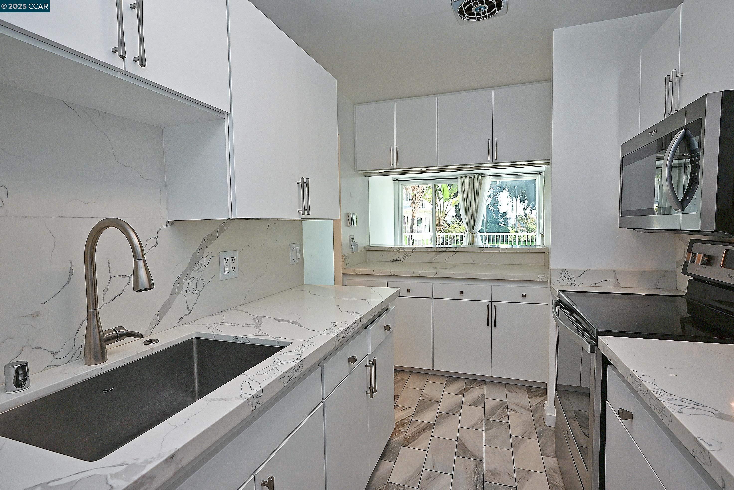 1425 Lakeside Drive, Unit 101 Oakland, CA 94612 - Photo 16 of 36 a kitchen with a sink stove and cabinets