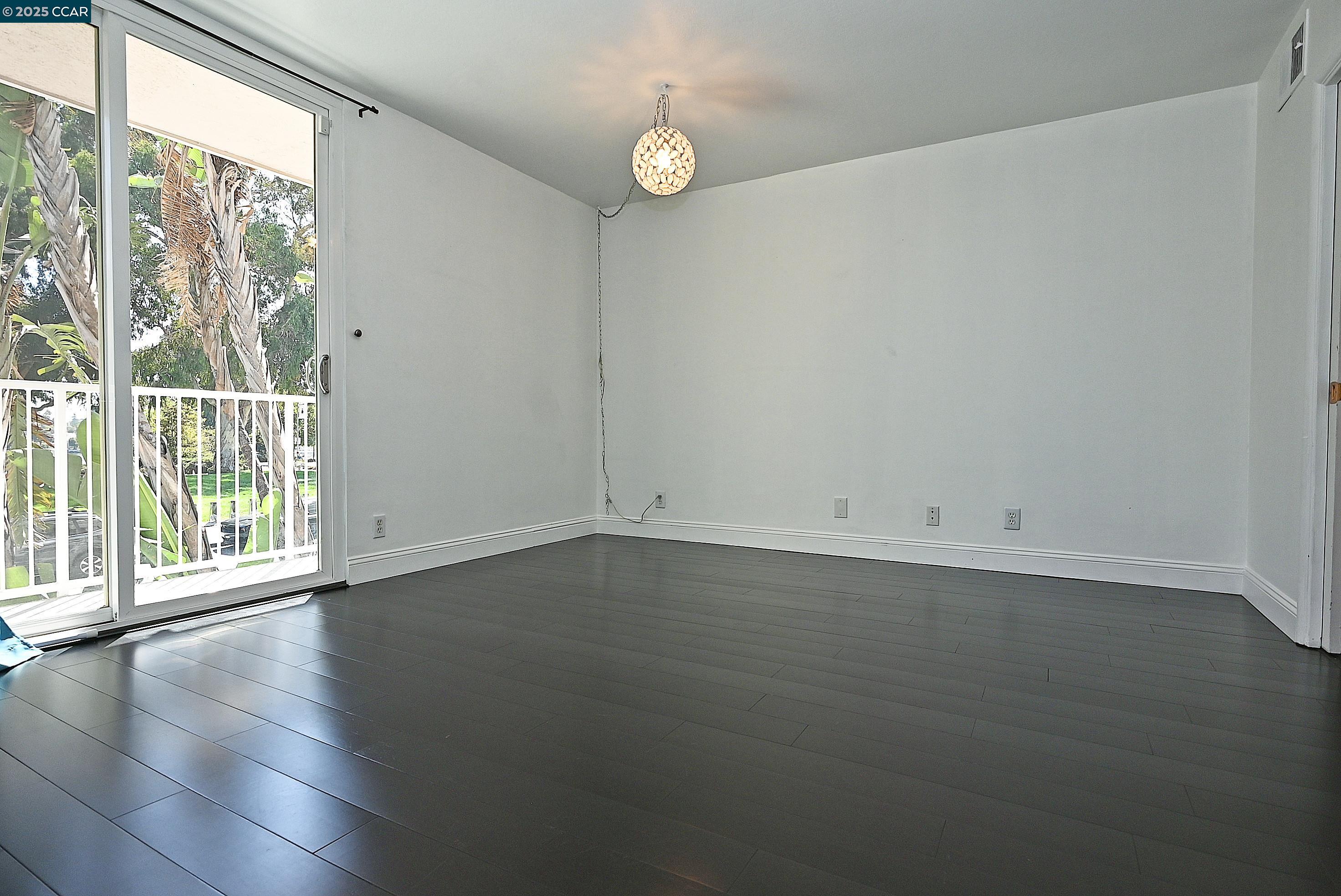 1425 Lakeside Drive, Unit 101 Oakland, CA 94612 - Photo 20 of 36 an empty room with wooden floor and windows