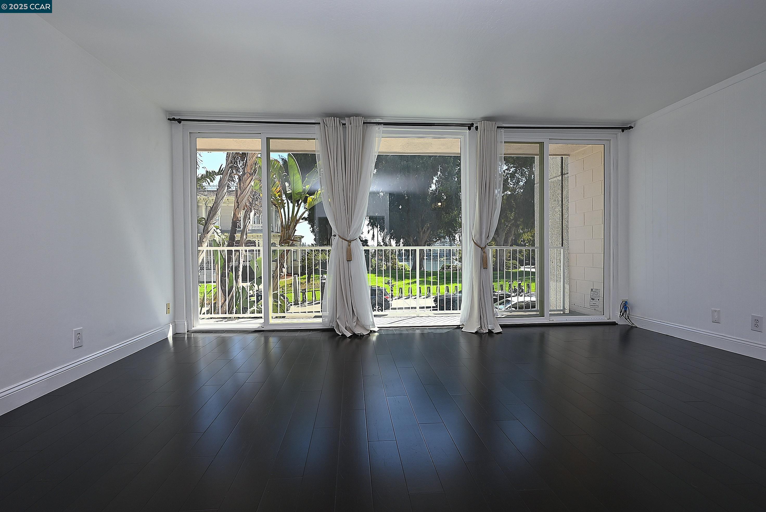 1425 Lakeside Drive, Unit 101 Oakland, CA 94612 - Photo 8 of 36 a view of an empty room with wooden floor and a window
