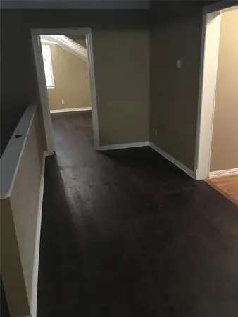 a view of a livingroom with wooden floor and a window