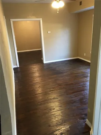 an empty room with wooden floor and entrance