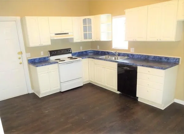 a kitchen with granite countertop a sink and a stove