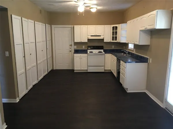 a kitchen with kitchen island a sink appliances and cabinets