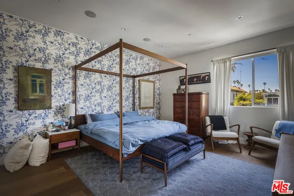 a bedroom with furniture and a large window